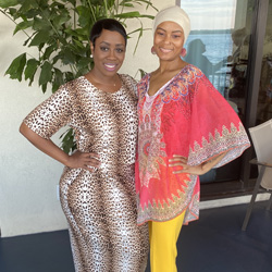 Two women smiling to the camera.